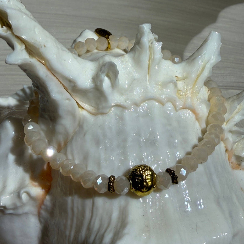 Bracelet en perles de verre facettées scintillantes Ton blanc crème avec Petit Charm bouddha en acier doré