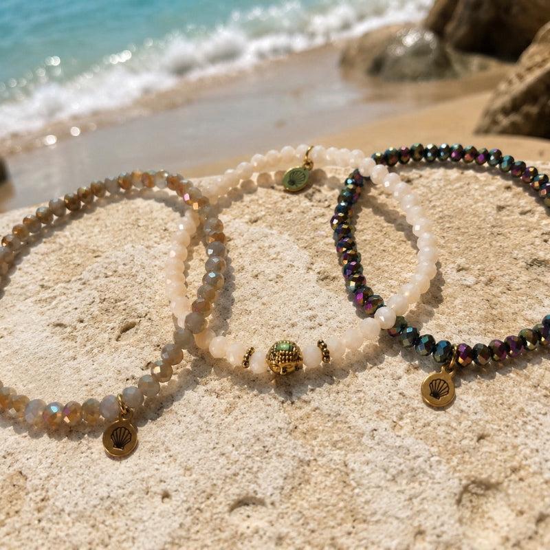 Bracelet with sparkling faceted glass beads in cream white with a small gold-plated steel Buddha charm